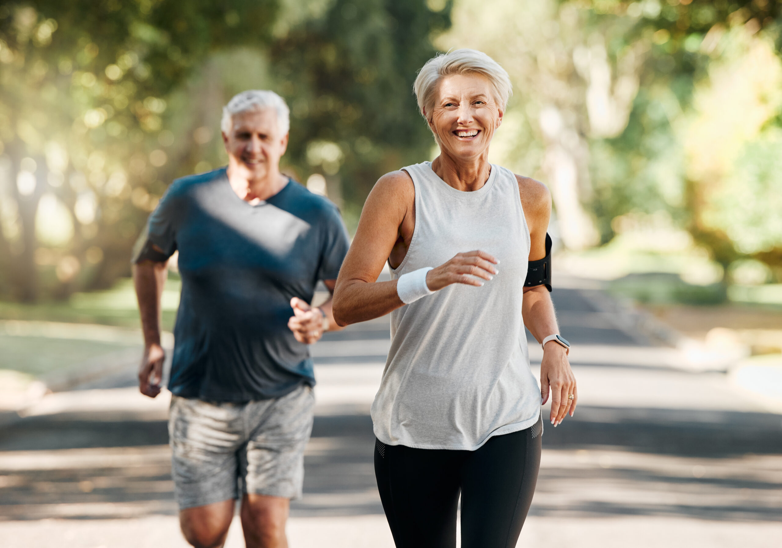 older couple exercising in park on sunny day